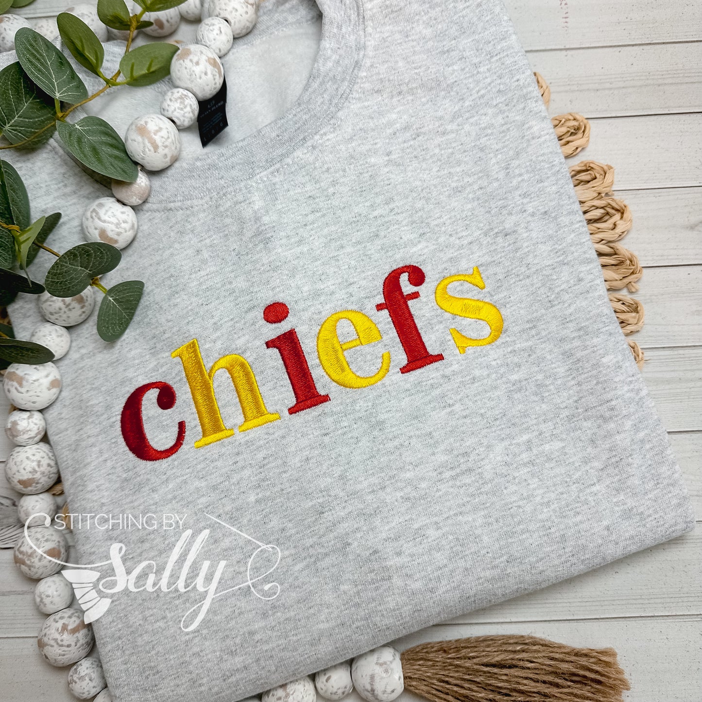 Close-up of embroidered chiefs lettering on grey crewneck sweatshirt