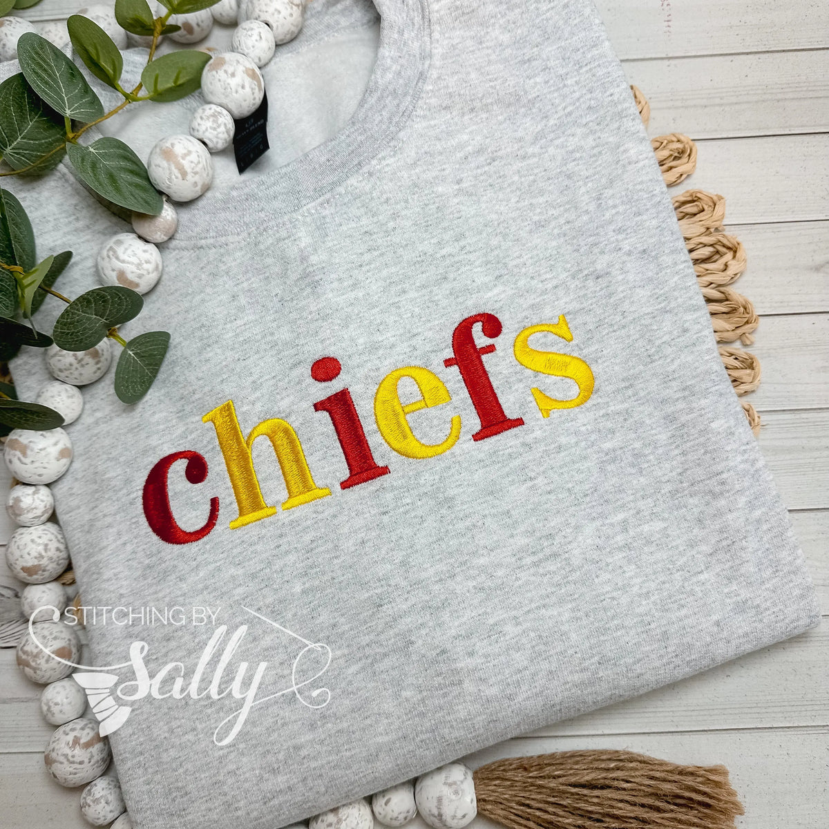 Close-up of embroidered chiefs lettering on grey crewneck sweatshirt
