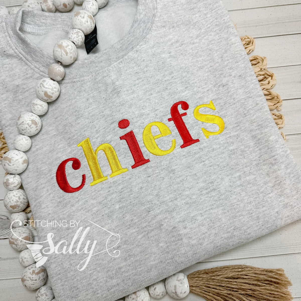 Grey Gildan sweatshirt with embroidered chiefs text in red and yellow