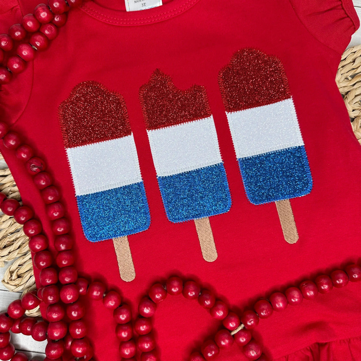 This red ruffle shirt features an applique design of the firecracker popsicle, in red, white and blue glitter htv.