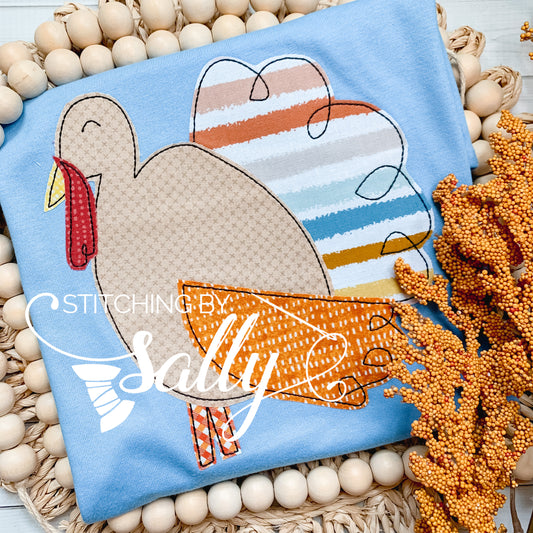 Flat lay of boys' fall turkey shirt with striped applique