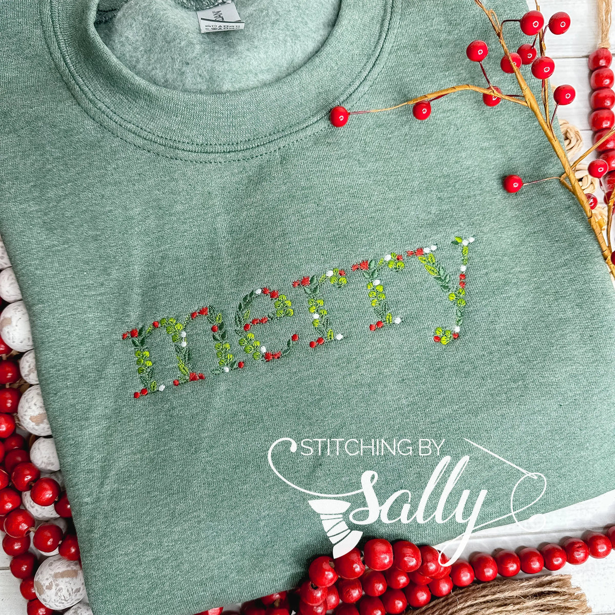 Green sweatshirt with "merry" embroidered in festive leaves and berries font, perfect for adding a touch of cheer to your wardrobe.