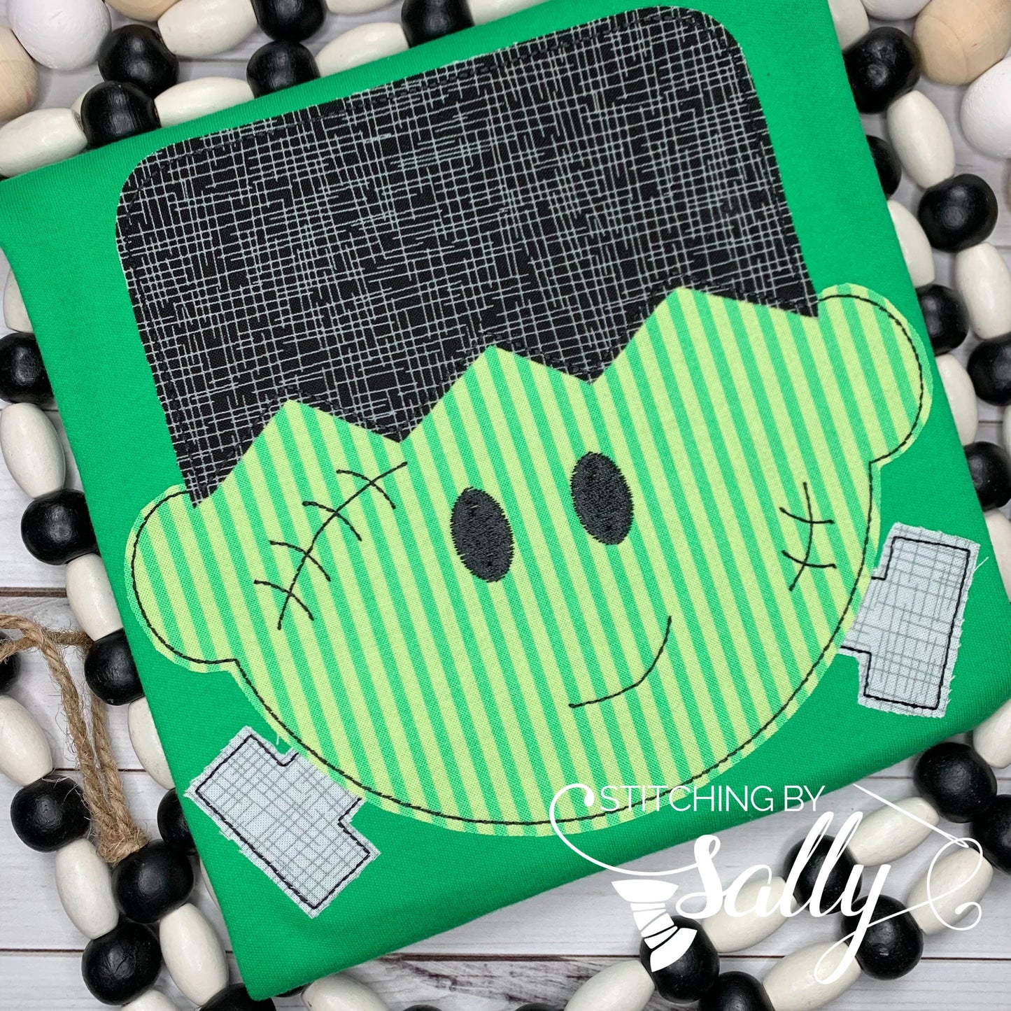 A green Halloween shirt with a Frankenstein character appliqué on the front.