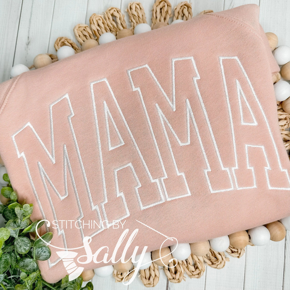 MAMA embroidered in white thread on a peach colored Bella Canvas sweatshirt
