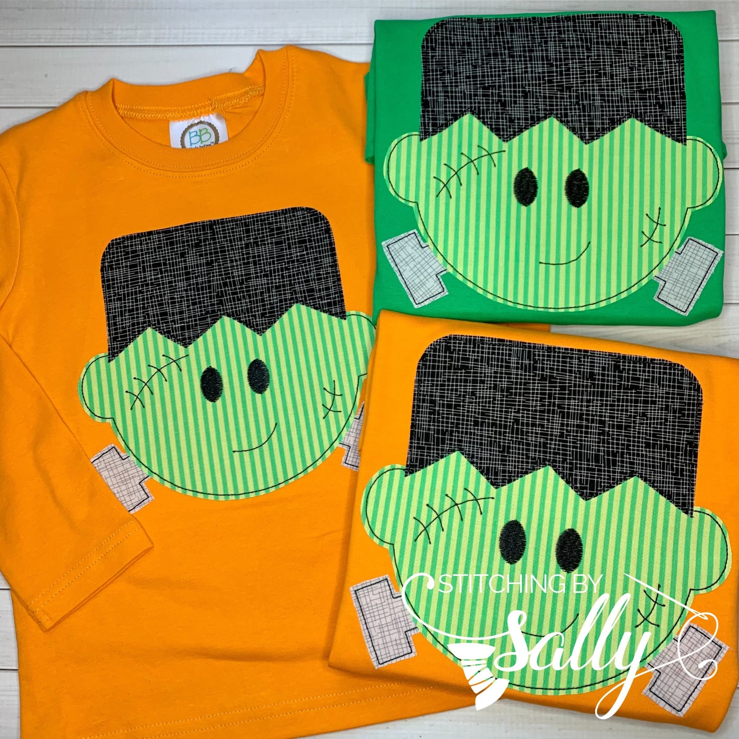 Three boys’ Halloween shirts with Frankenstein appliqué design on orange and green shirts.
