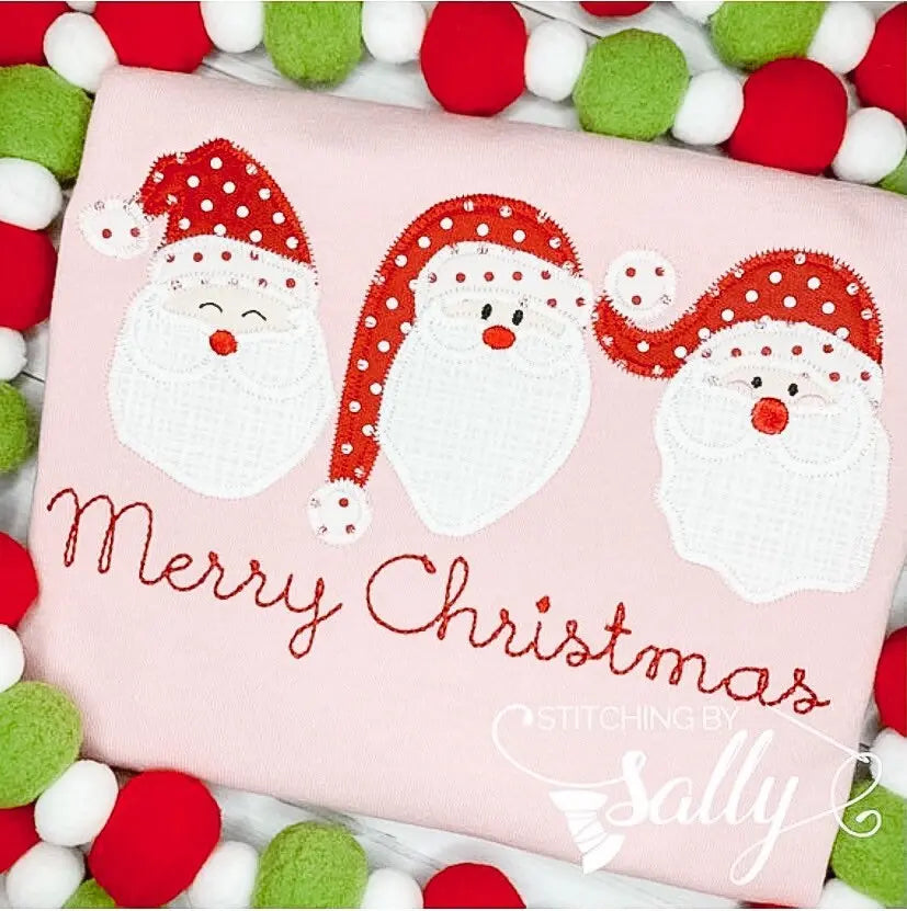 Close up of the santa trio applique on a pink shirt
