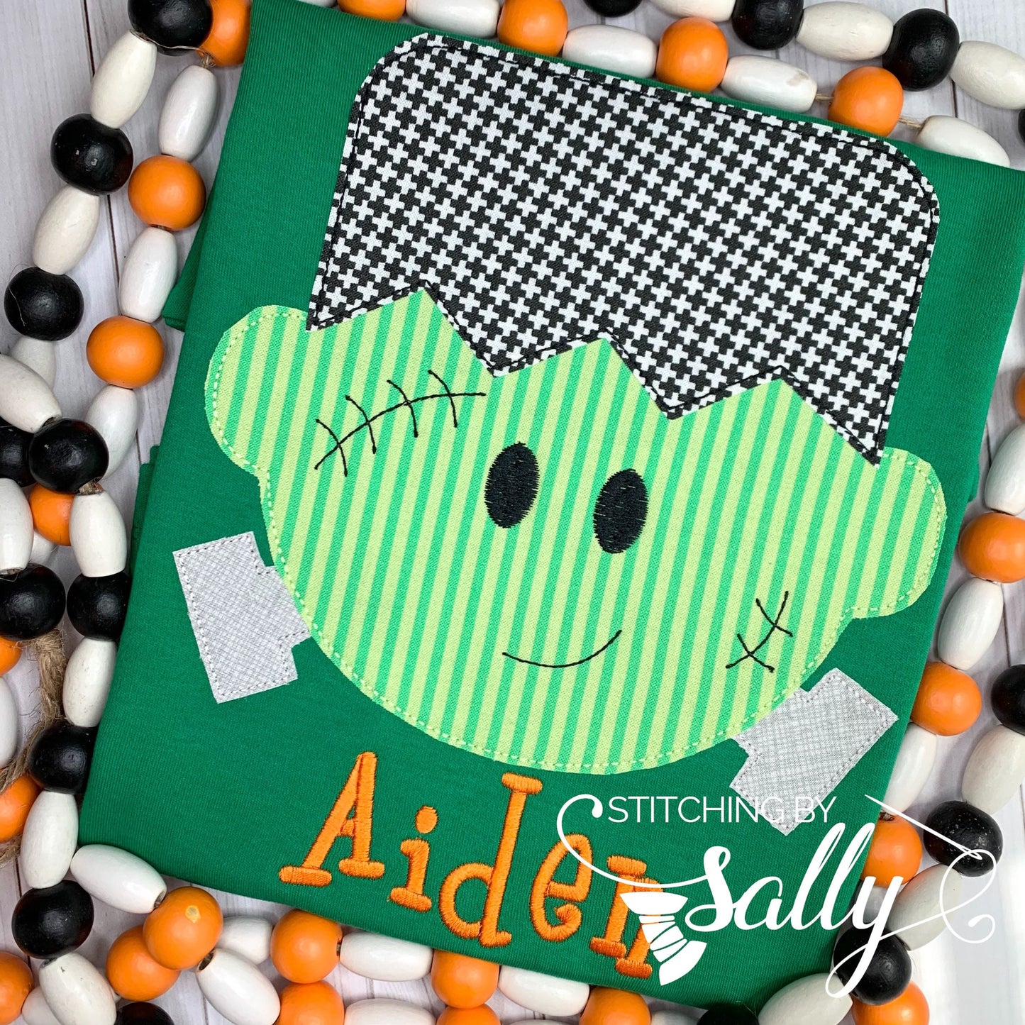 Close-up of friendly Frankenstein face with detailed stitching on green shirt