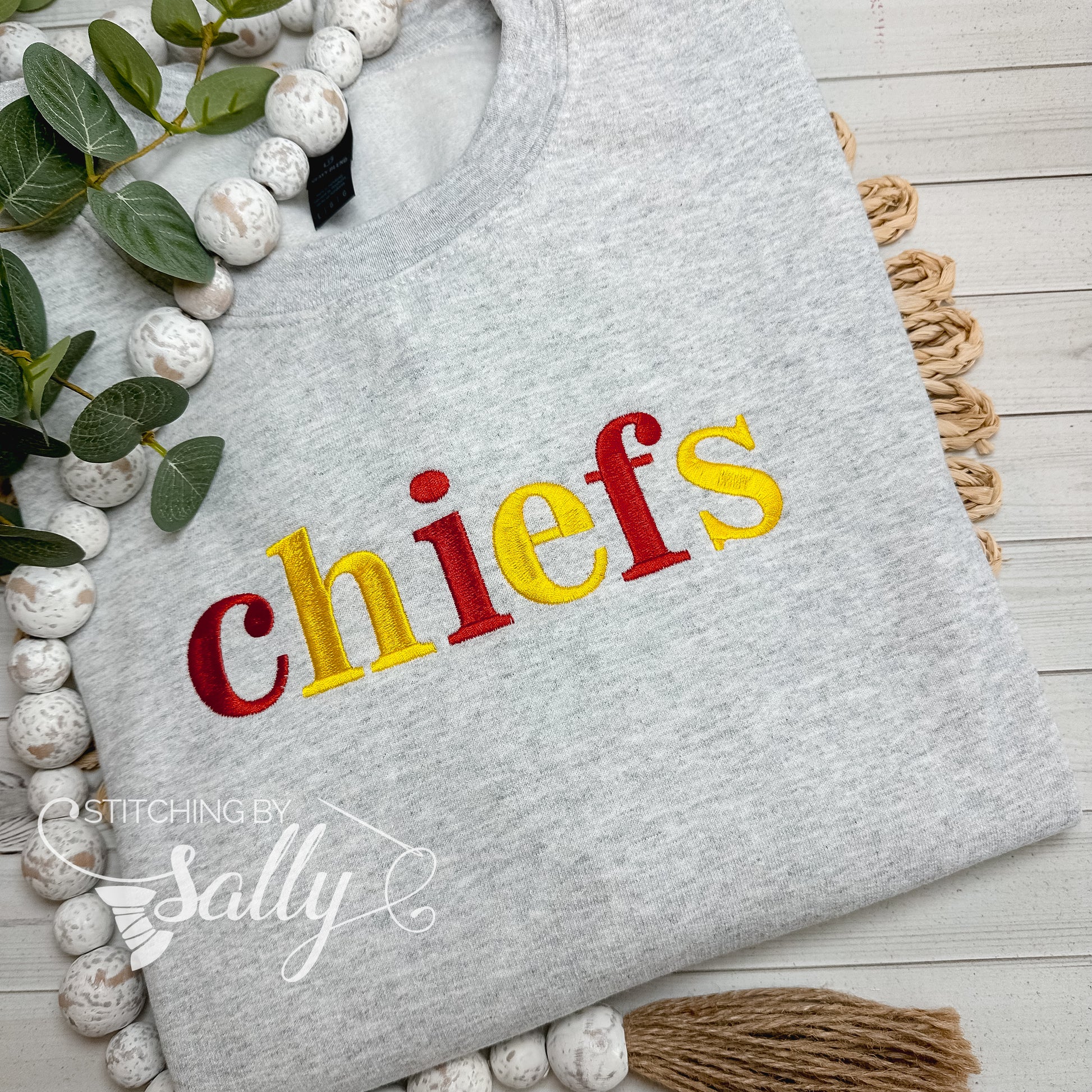 Close-up of embroidered chiefs lettering on grey crewneck sweatshirt