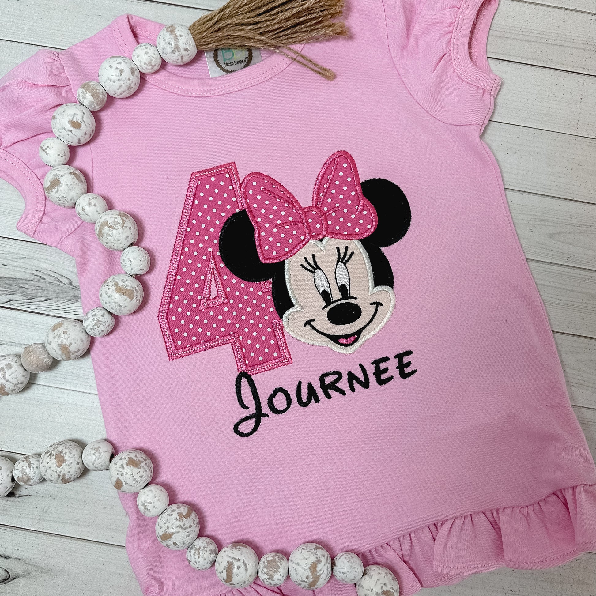 Pink shirt with Minnie applique and a number 4. Shirt can be personalized