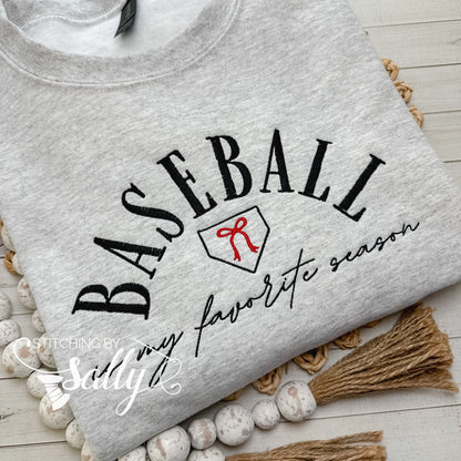 A grey sweatshirt with the words “baseball is my favorite season” embroidered on it with a cute red bow. Colors can be customized to match your favorite team!