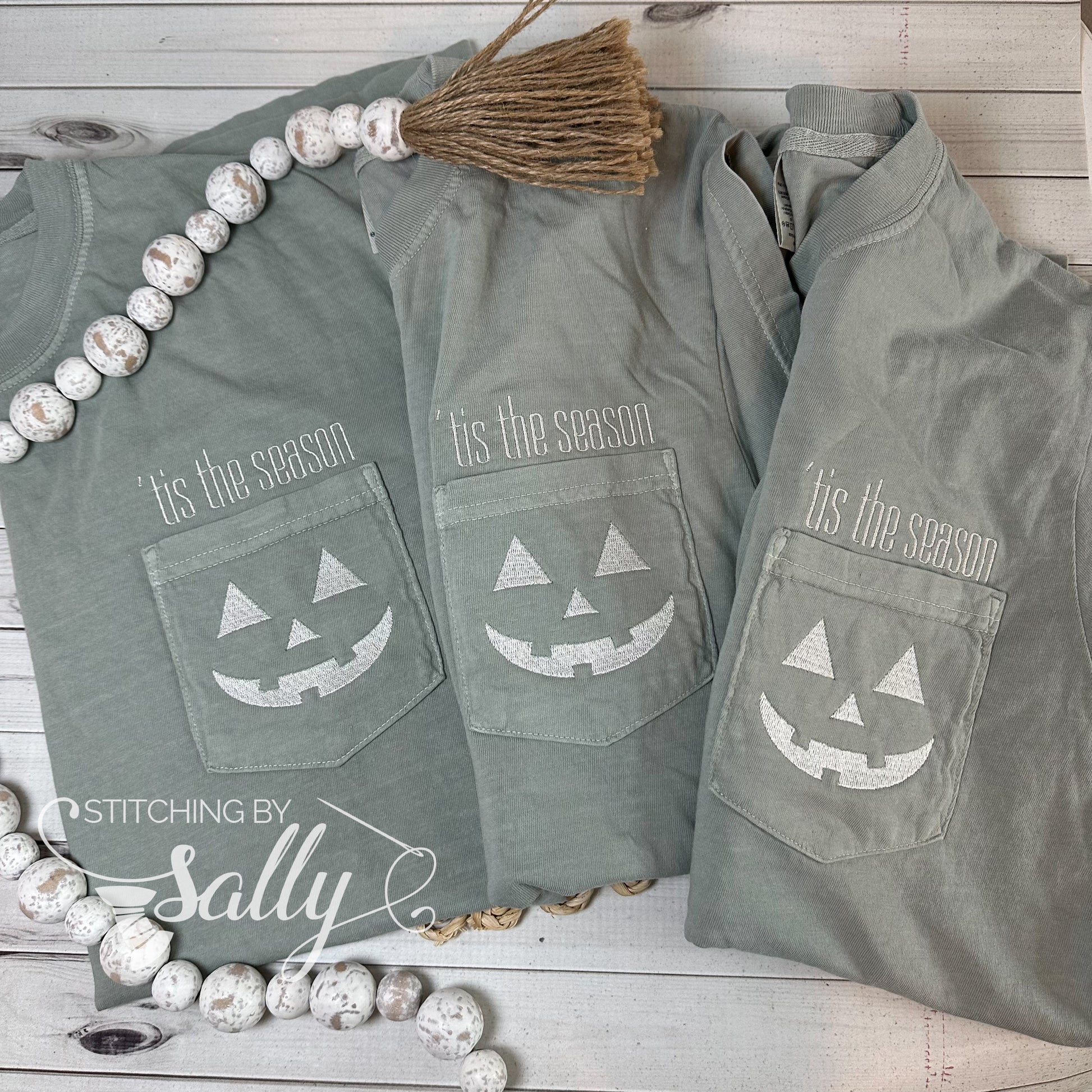 A group of three shirts with a Halloween design embroidered on the pocket 