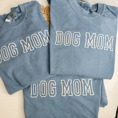 Three blue sweatshirts with 'DOG MOM' embroidered in white thread. 