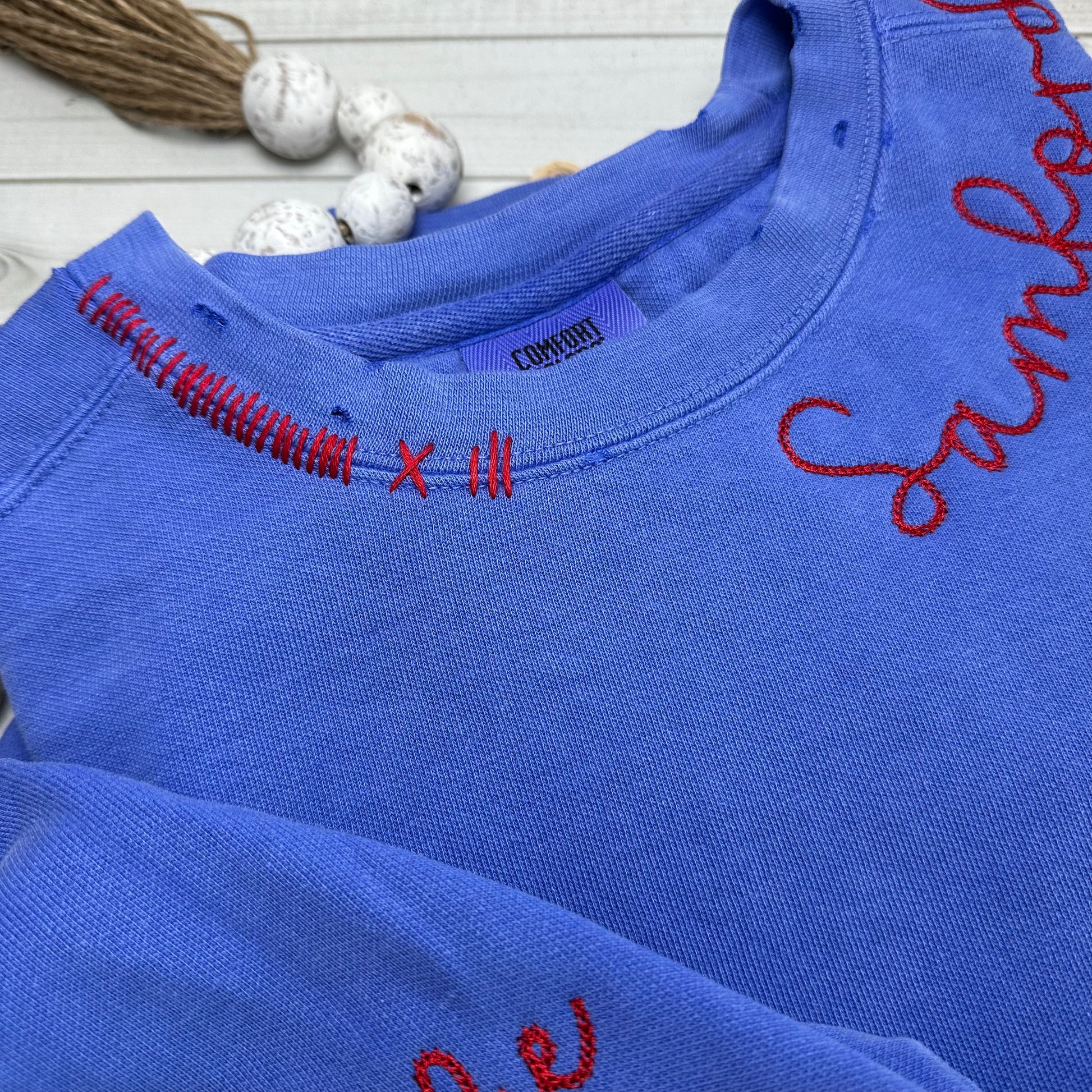 CLose up of neckline stitching and hand distressing