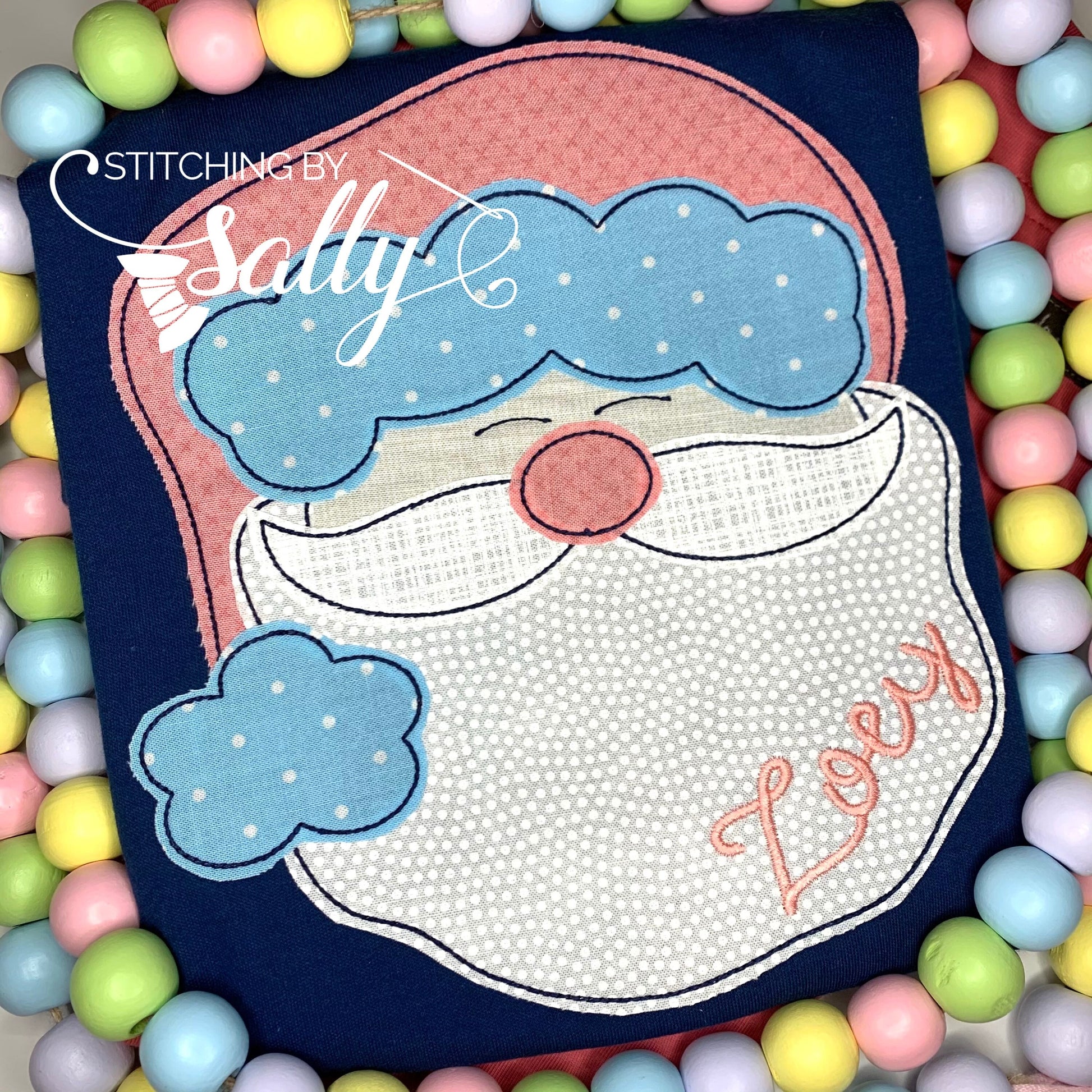 Close up of santa face appliquéd on a navy shirt