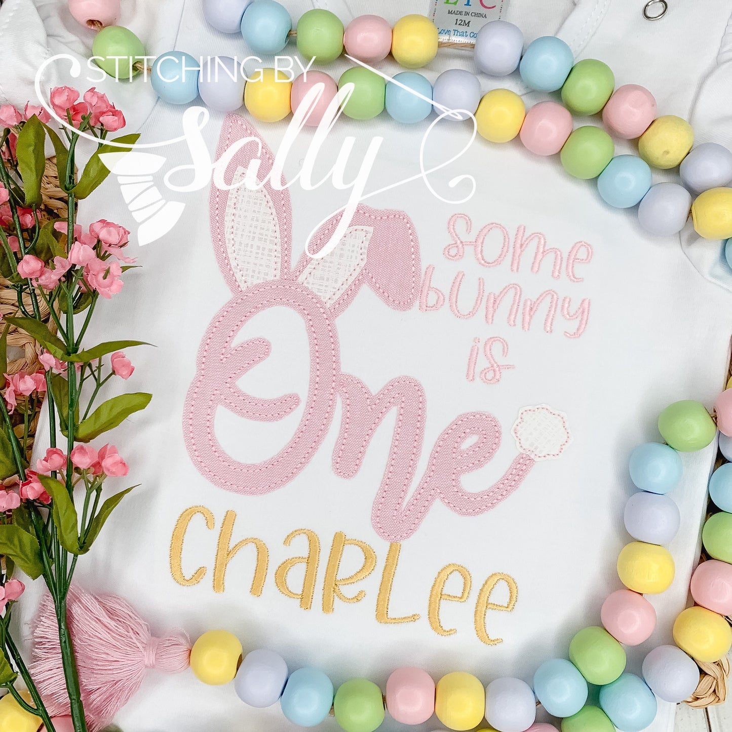 Some Bunny Is One birthday appliqué shirt with applique bunny design in pink, perfect for a first birthday celebration.