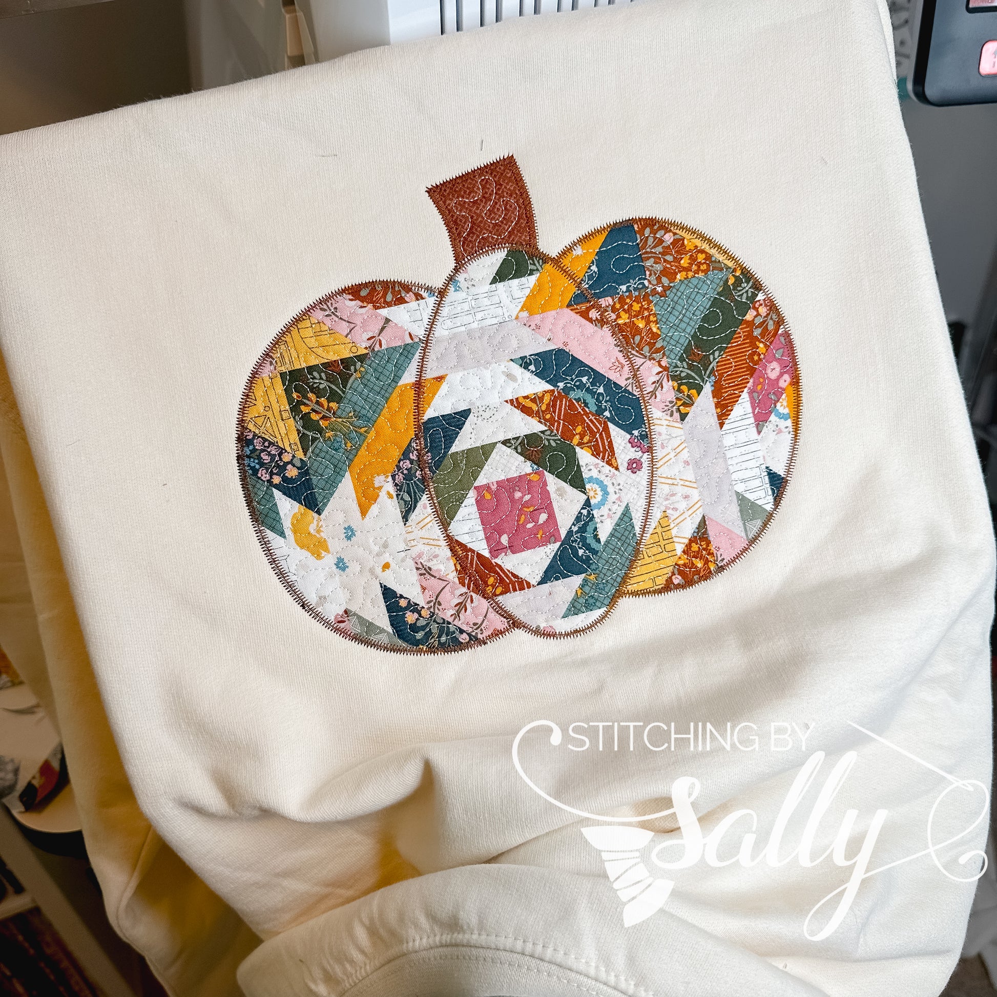 Front view of quilted harvest pumpkin appliqué crewneck sweatshirt