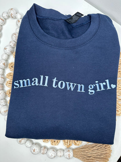 Navy blue sweatshirt with 'small town girl' embroidered in light blue thread. 
