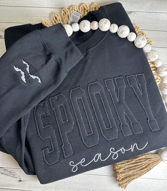 Black sweatshirt with “SPOOKY Season” tonal appliqué on front