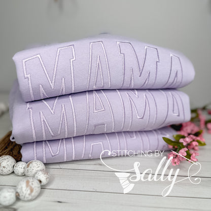 Close-up of lavender thread embroidered "MAMA" design, stack of three