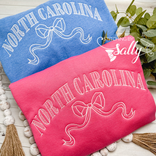 Striped North Carolina embroidered sweatshirt with a coquette bow, available in custom sweatshirt and thread colors.