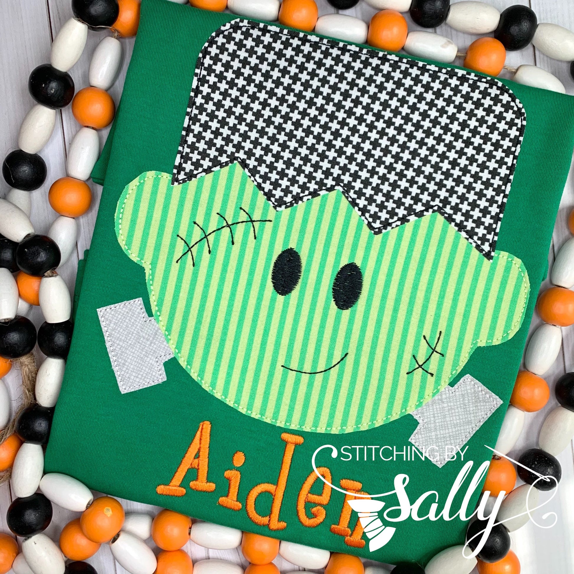 Close-up of friendly Frankenstein face with detailed stitching on green shirt