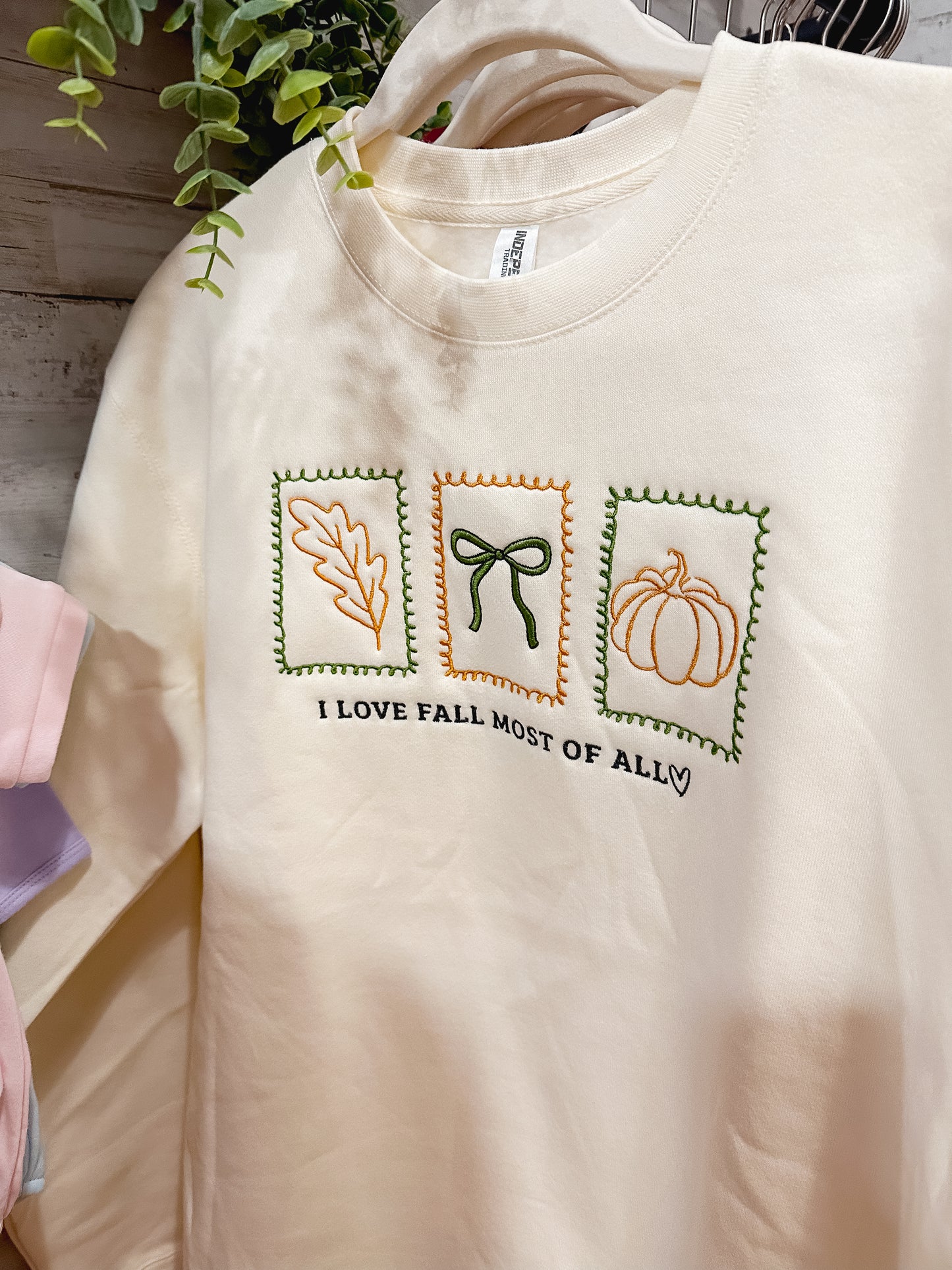 Cream sweatshirt with I Love Fall Most of All embroidered in fall colors.