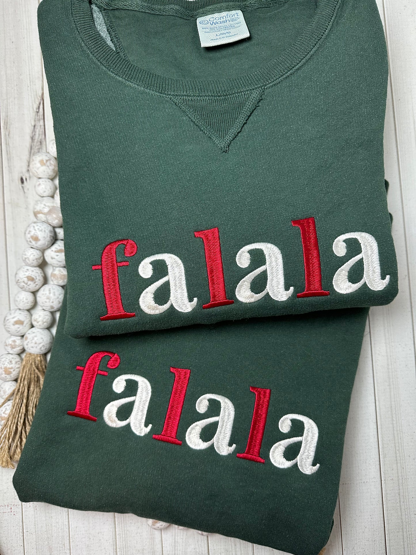 Dark green Hanes Comfort Wash Christmas sweatshirt with red and cream embroidered falala.
